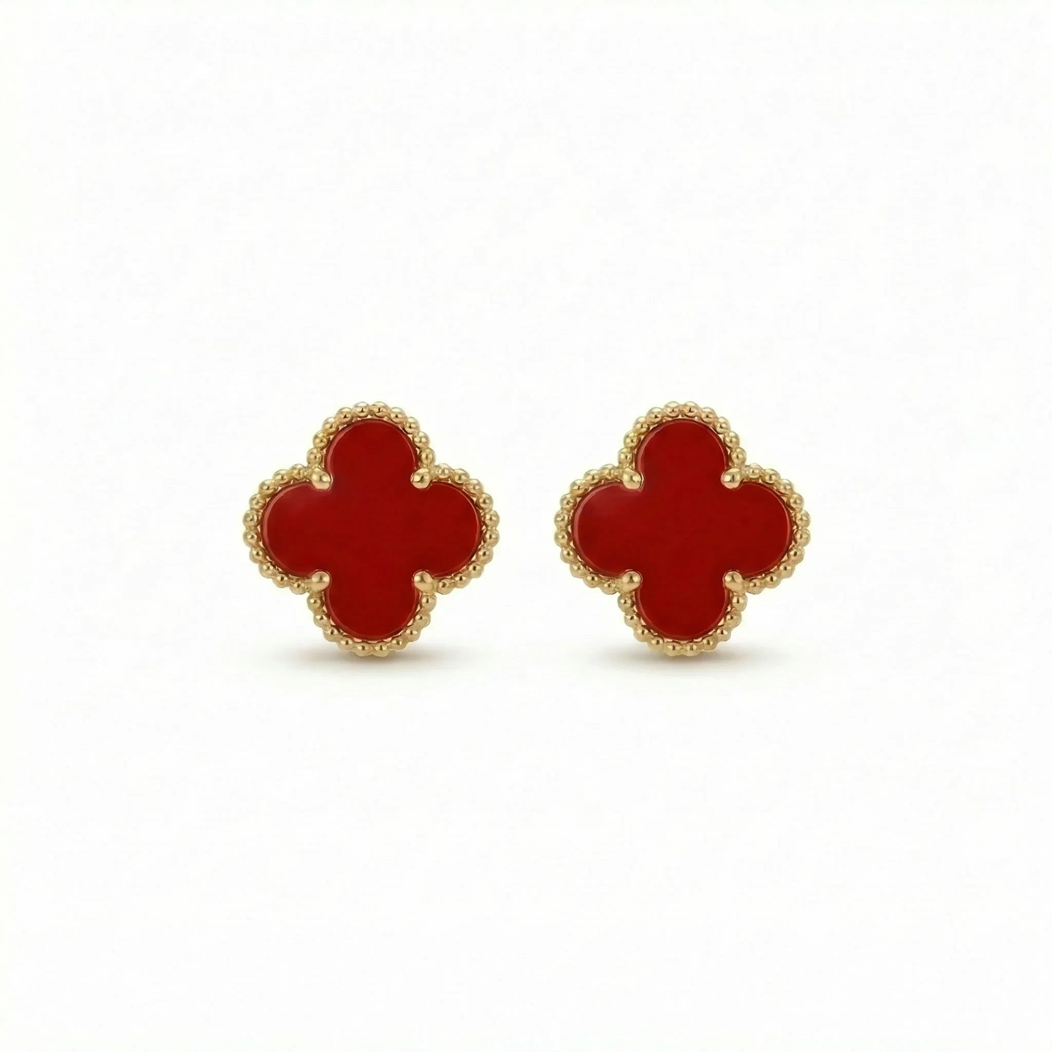 Gold clover-shaped stud earrings with red enamel, elegant jewelry on white background