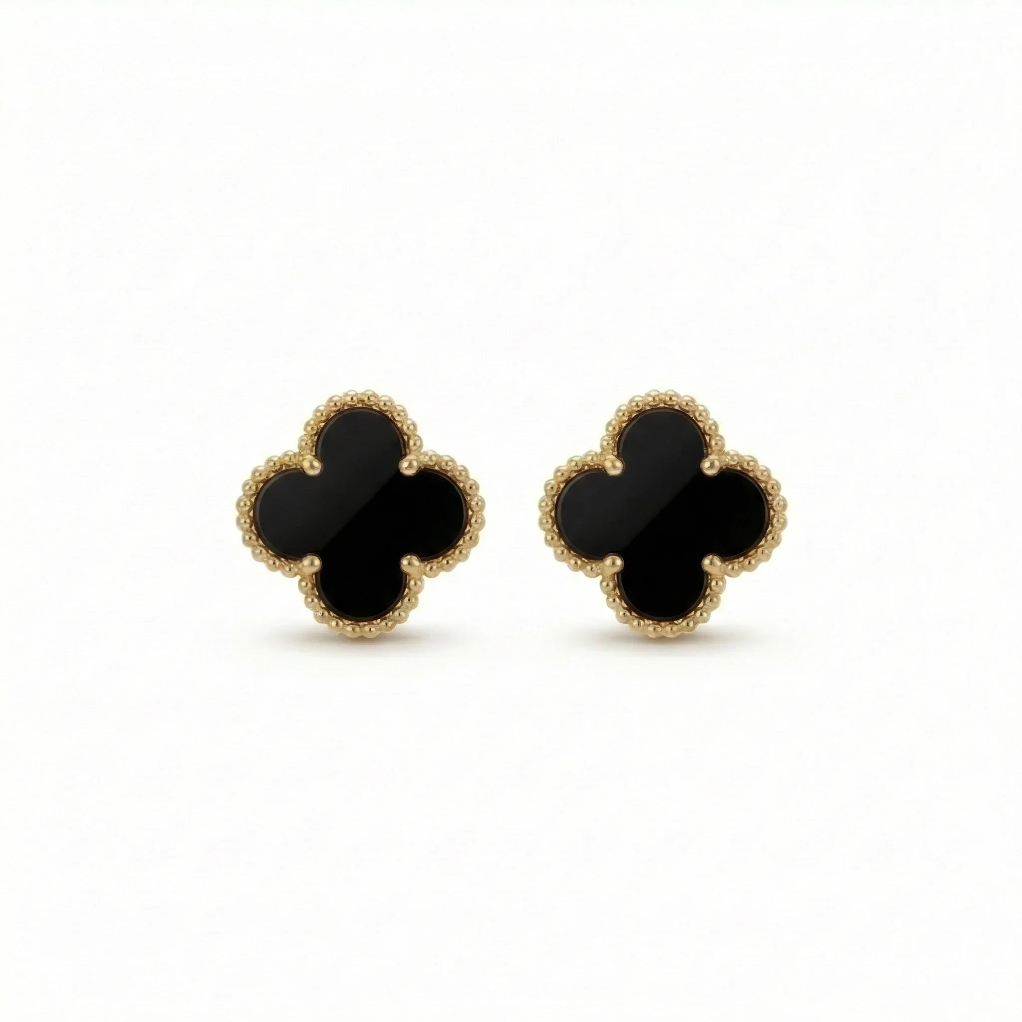 Gold clover-shaped stud earrings with black onyx center on white background