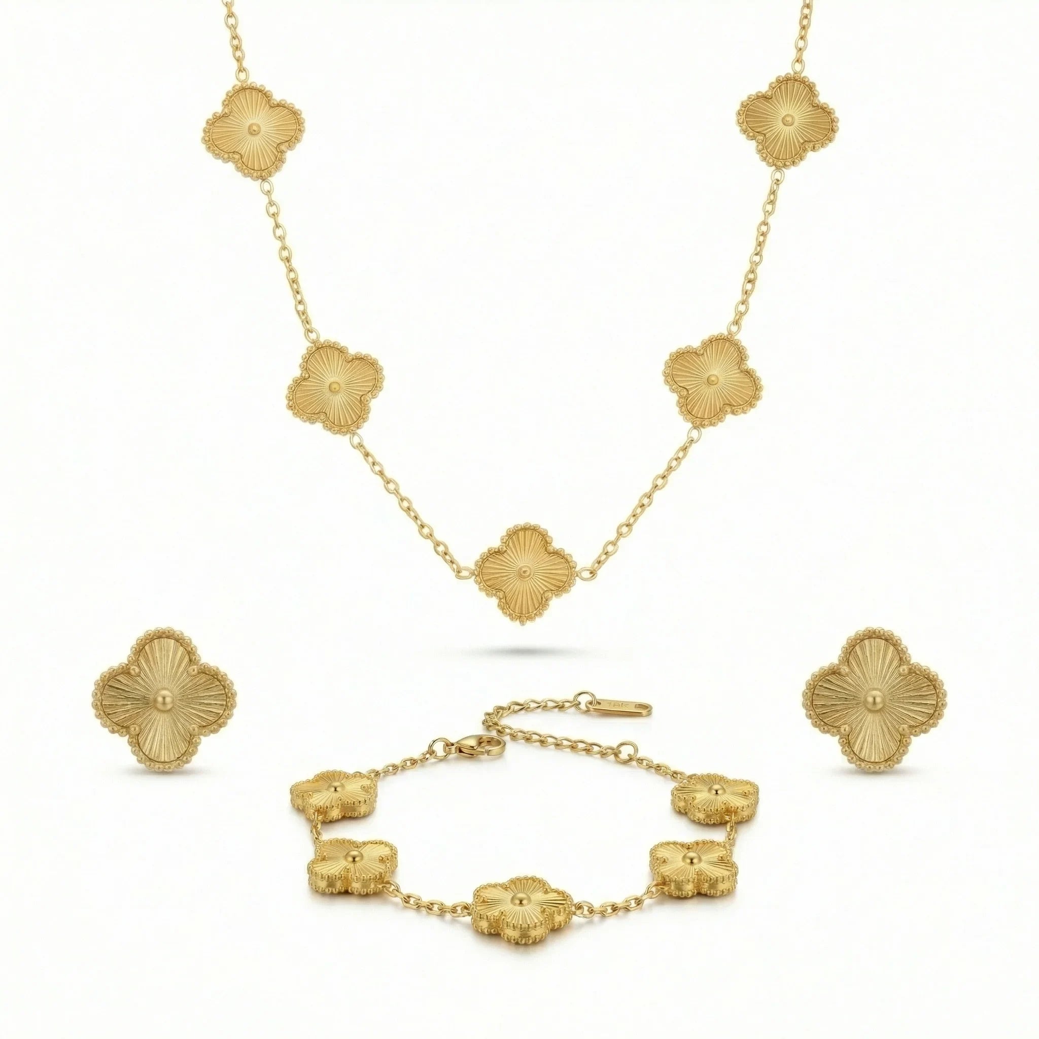 Gold jewelry set with floral clover design, including necklace, bracelet, and earrings