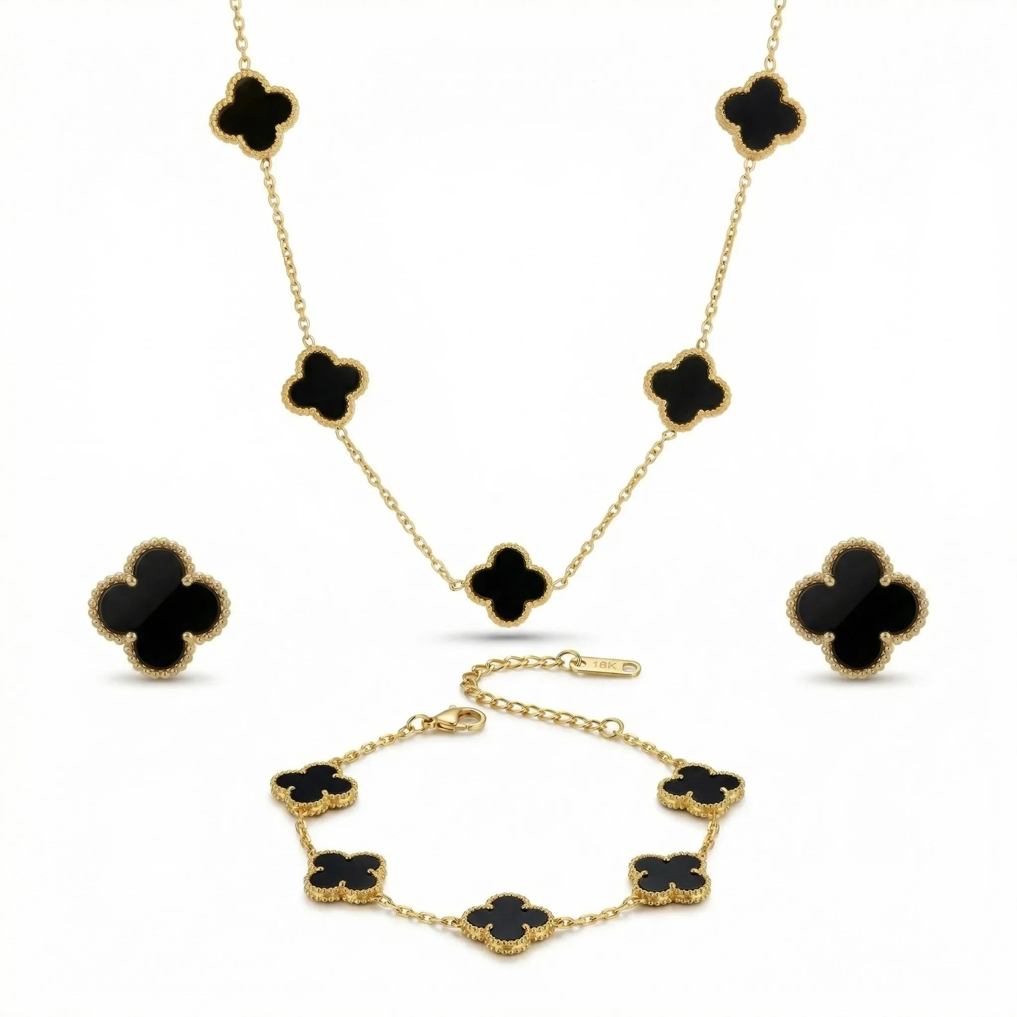 Gold jewelry set with black clover-shaped stones including necklace, bracelet, and earrings